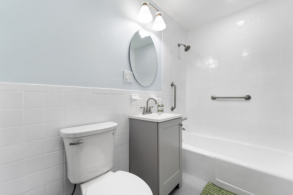 34 Hamilton Road, Unit 302 Arlington, MA 02474 - Photo 18 of 30 a bathroom with a toilet sink and mirror