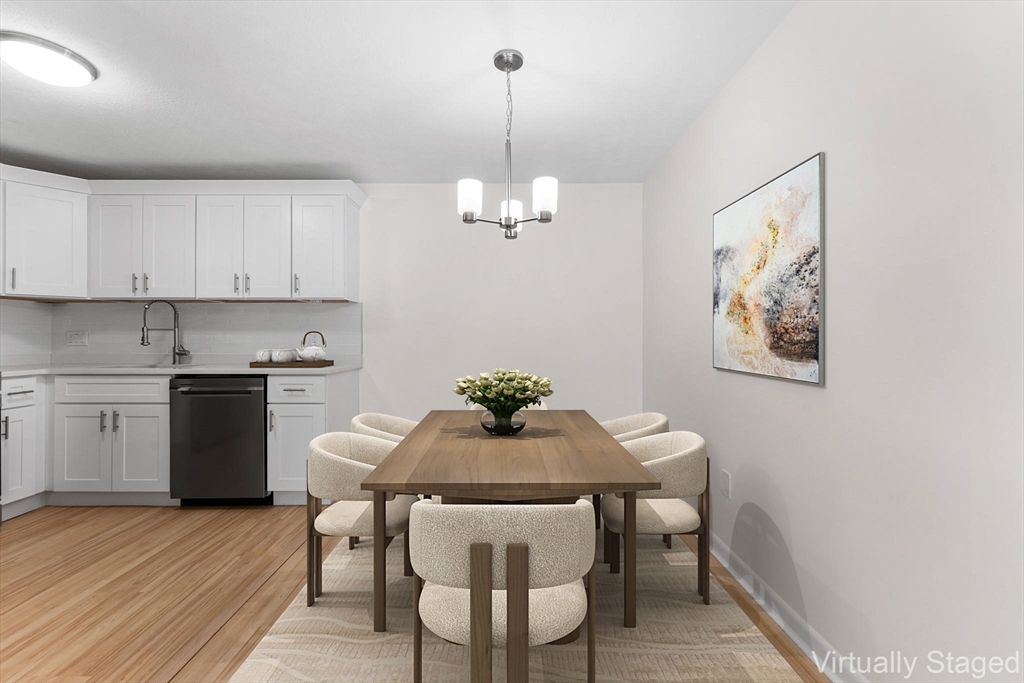 34 Hamilton Road, Unit 302 Arlington, MA 02474 - Photo 7 of 30 a view of a dining room with furniture wooden floor and a chandelier