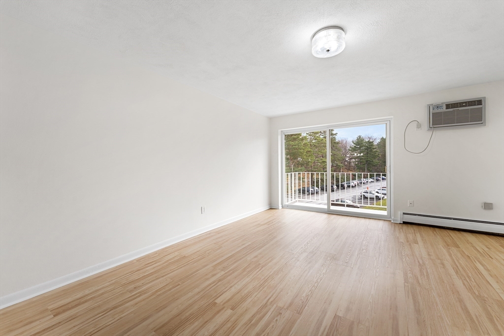 34 Hamilton Road, Unit 302 Arlington, MA 02474 - Photo 9 of 30 a view of an empty room with wooden floor and a window