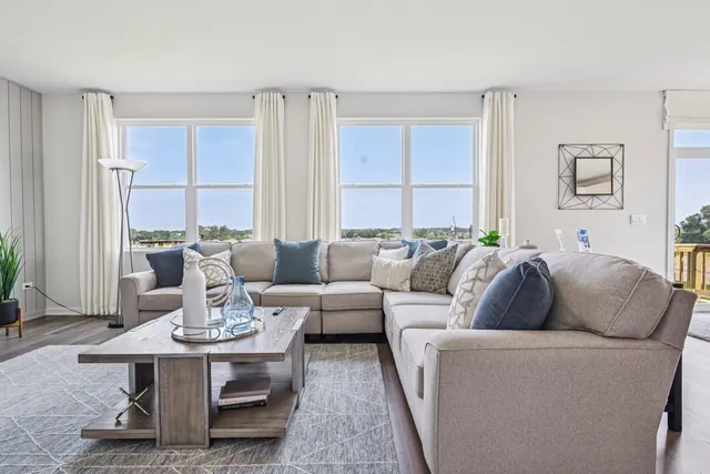 a living room with furniture kitchen view and large window