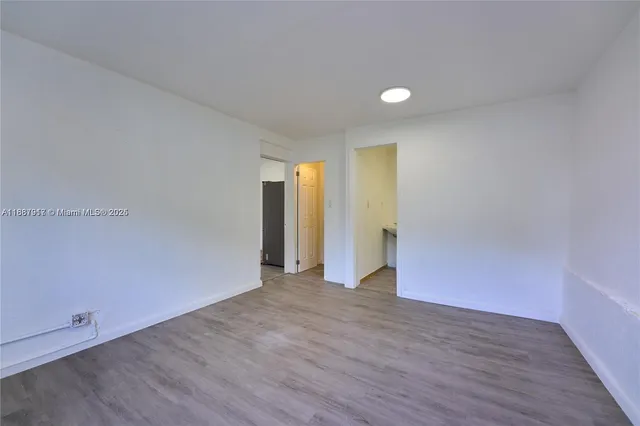 a view of an empty room with wooden floor