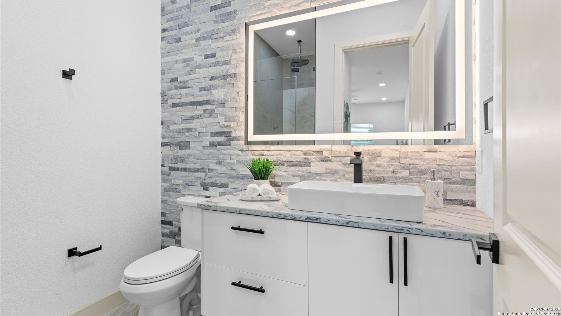 22327 Scenic Loop Road San Antonio, TX 78255 - Photo 50 of 59 a bathroom with a granite countertop sink a toilet and a mirror