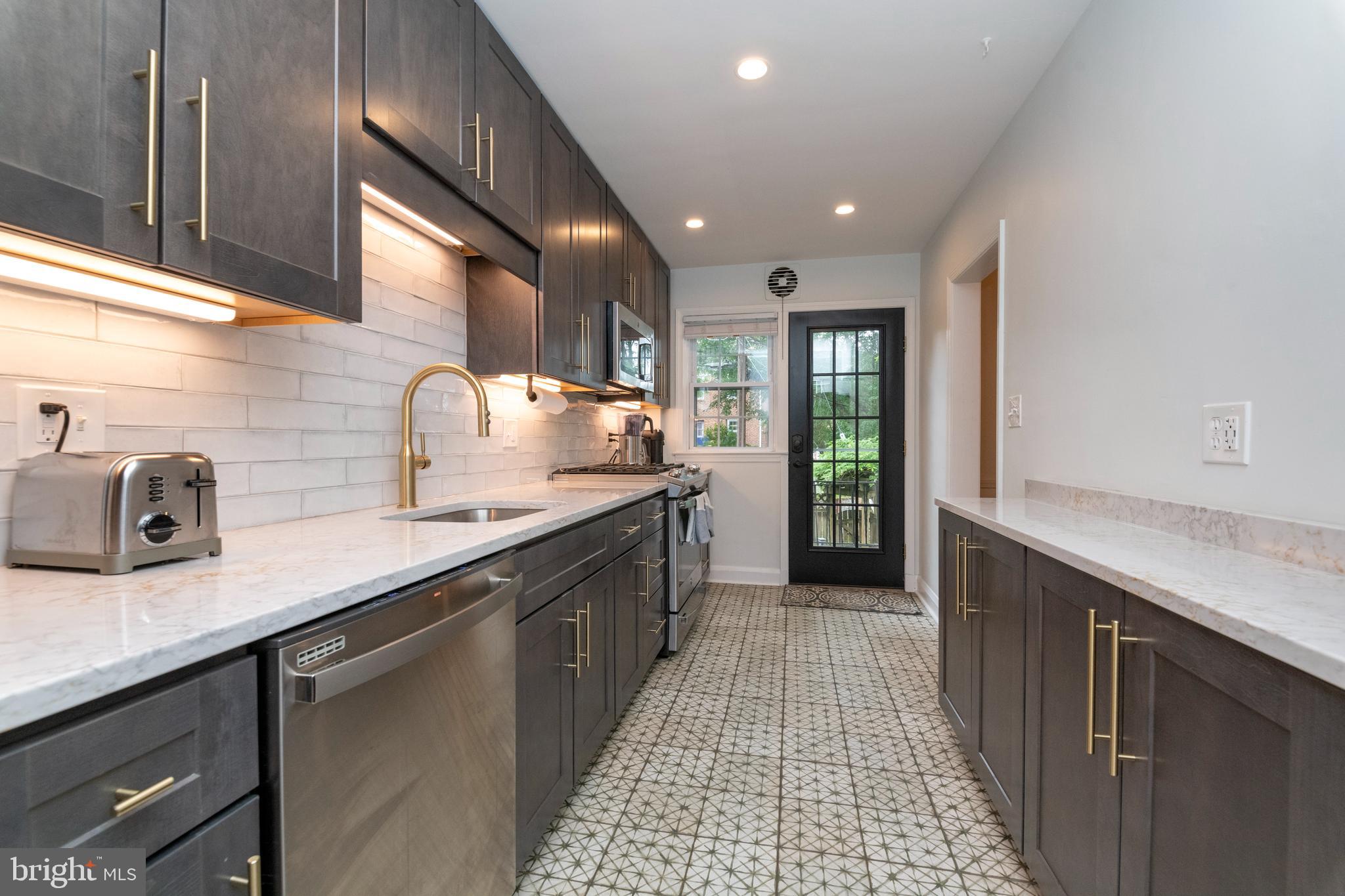 115 Brandon Road Baltimore, MD 21212 - Photo 12 of 39 a kitchen with stainless steel appliances granite countertop a sink a stove and a wooden cabinets