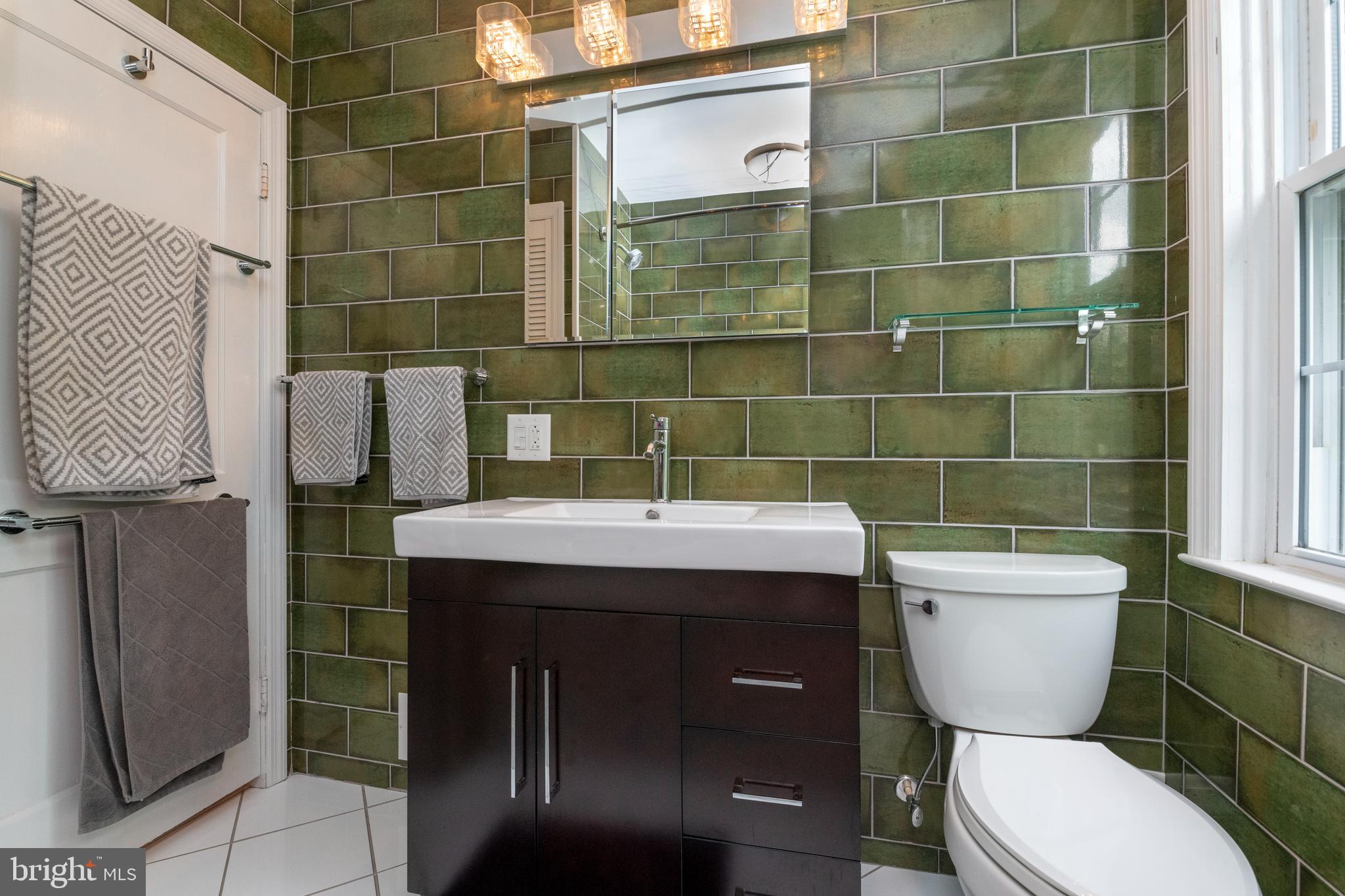 115 Brandon Road Baltimore, MD 21212 - Photo 20 of 39 a bathroom with a sink a toilet and a mirror