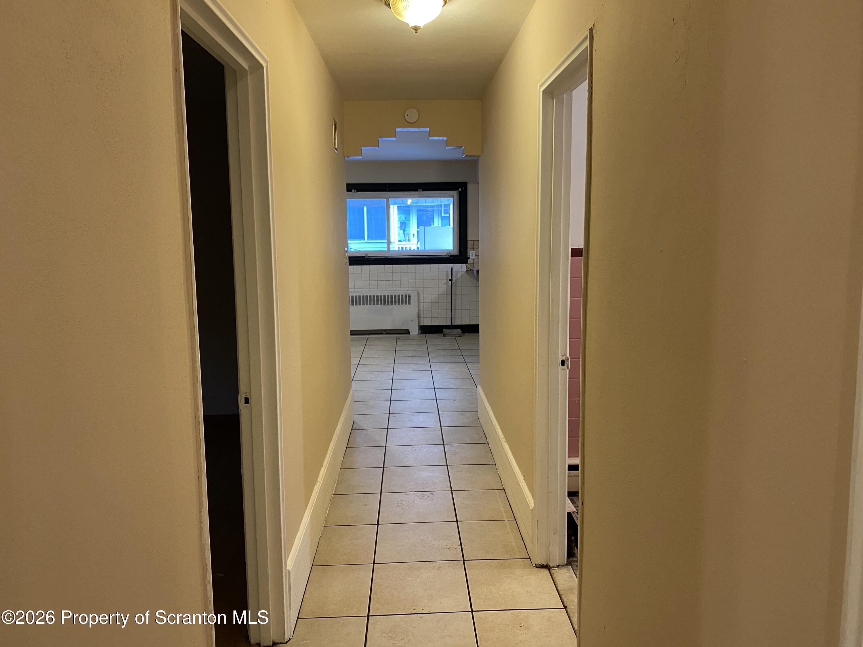 414 Orchard Street Scranton, PA 18505 - Photo 10 of 20 a view of a hallway with wooden floor and a living room