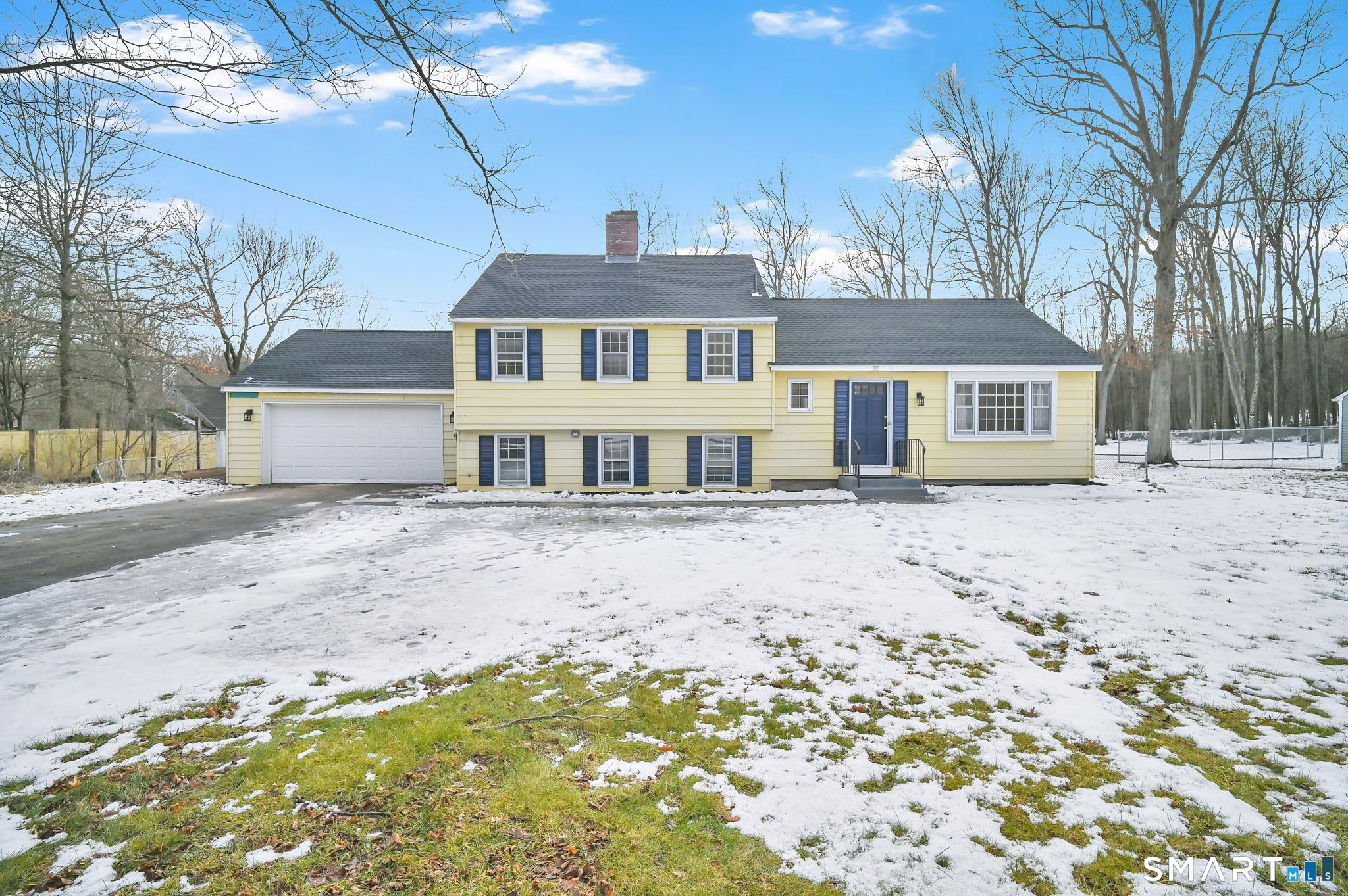 a front view of a house with a yard covered in snow