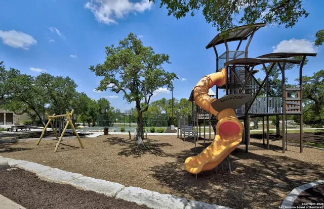 a view of a swimming pool with lawn chairs and potted plants