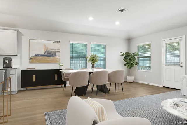 a living room with furniture a potted plant and a wooden floor