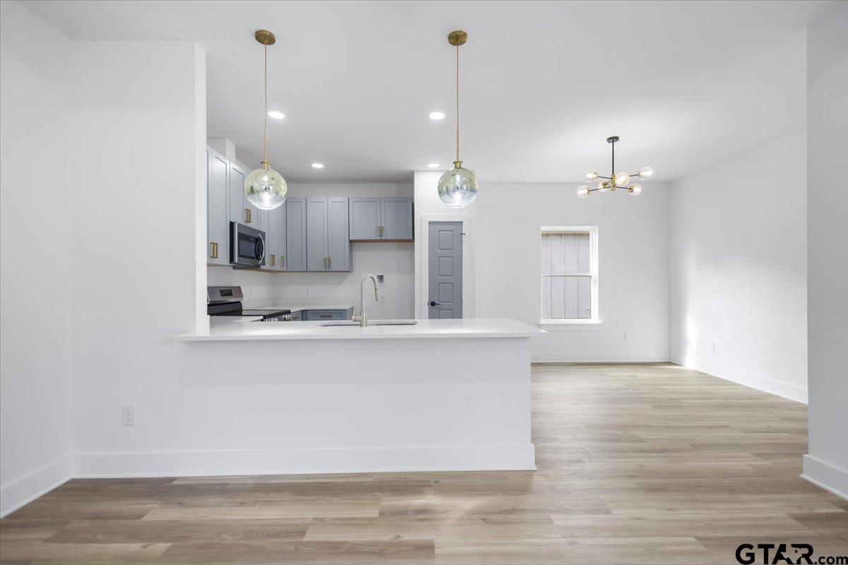 228 South Fenton Avenue Tyler, TX 75702 - Photo 13 of 46 a view of a kitchen with a sink dishwasher a refrigerator and wooden floor