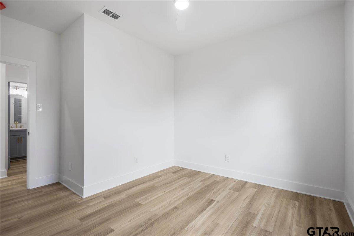 228 South Fenton Avenue Tyler, TX 75702 - Photo 22 of 46 a view of an empty room with wooden floor and a window