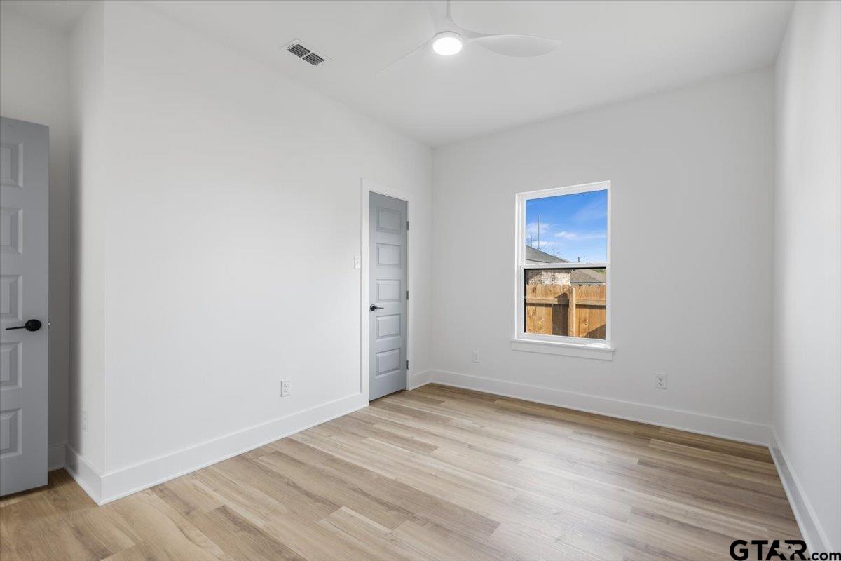 228 South Fenton Avenue Tyler, TX 75702 - Photo 33 of 46 a view of an empty room with wooden floor and a window