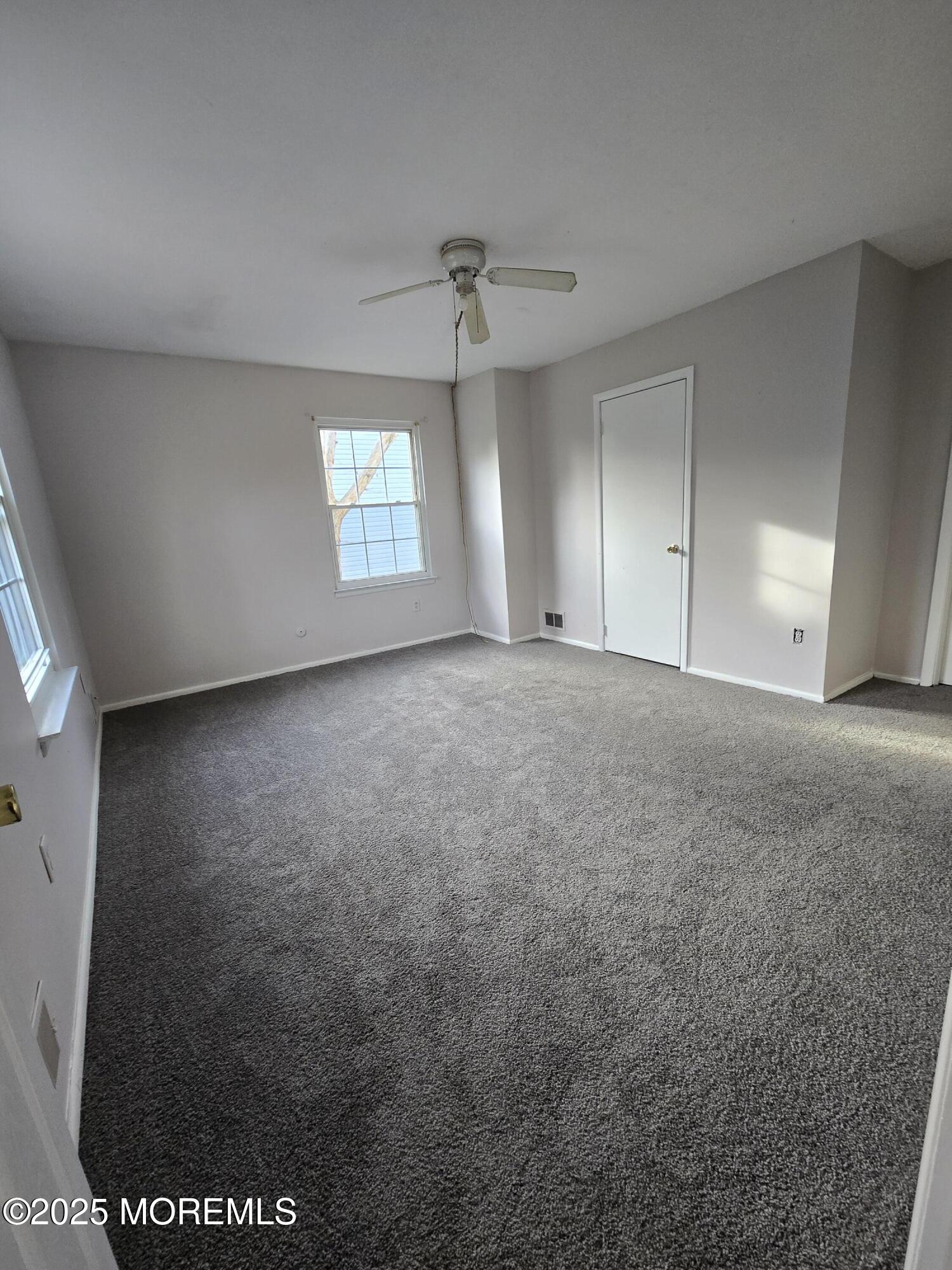 802 Miller Avenue Jackson, NJ 08527 - Photo 10 of 20 an empty room with windows and ceiling fan