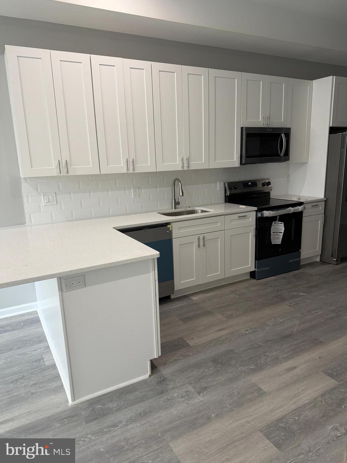 a kitchen with granite countertop white cabinets and stainless steel appliances