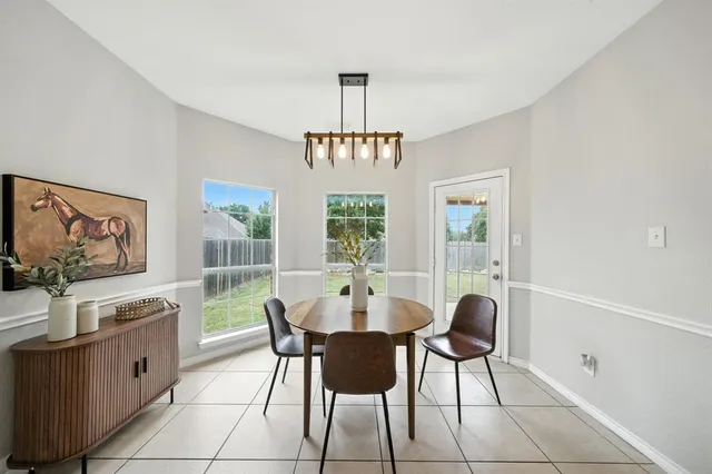 a dining room with furniture a chandelier and window
