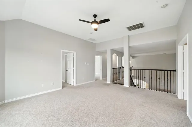a view of a big room with windows and chandelier fan