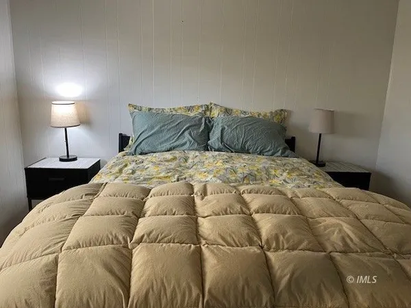 a large bed sitting in a bedroom next to a lamp