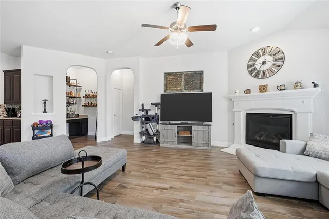 a living room with furniture a fireplace and a large window
