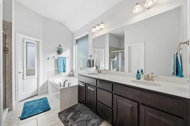 a spacious bathroom with a tub sink and mirror