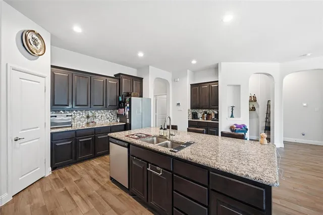 a kitchen with stainless steel appliances granite countertop a sink stove and microwave