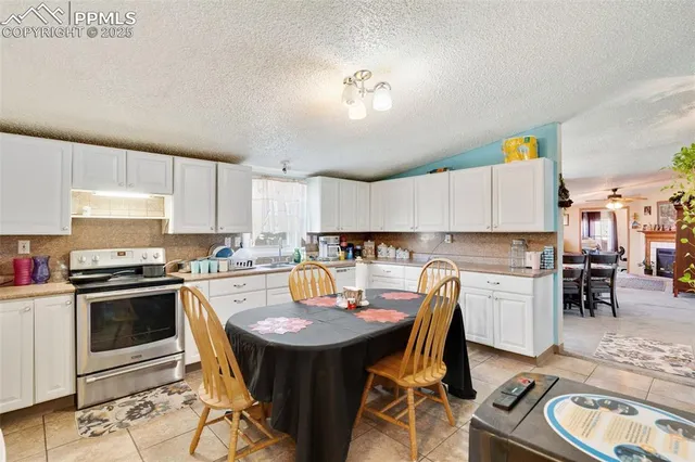 a kitchen with a sink a stove a kitchen island with chairs and cabinets