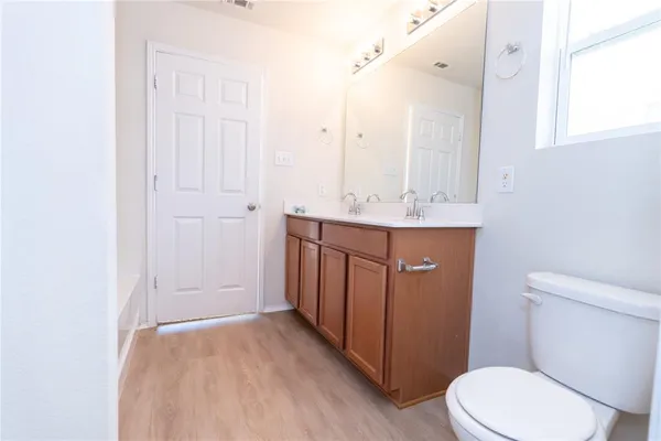 a bathroom with a sink a toilet a mirror and vanity