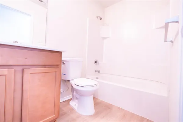 a bathroom with a white toilet and tub