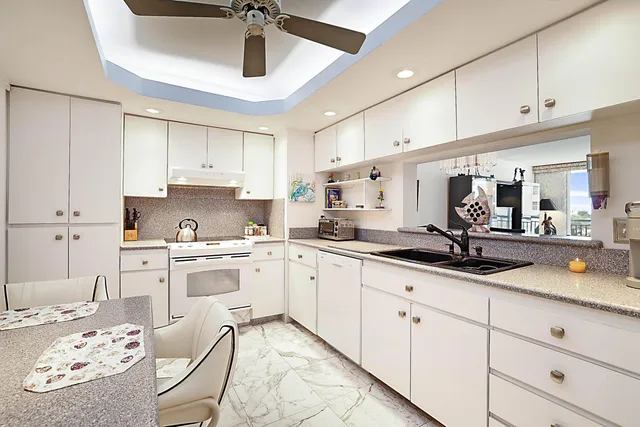 a kitchen with stainless steel appliances a white table and chairs