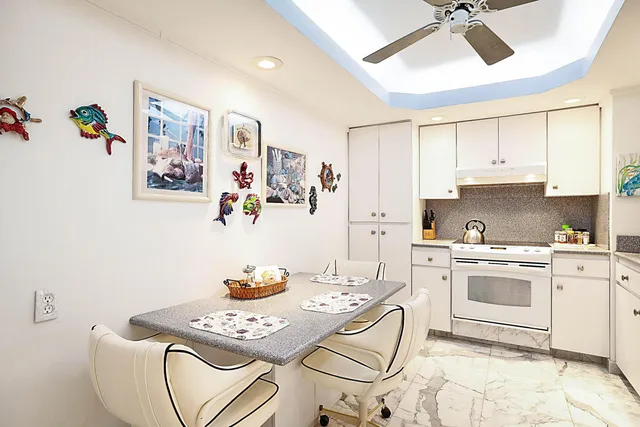 a kitchen with granite countertop white cabinets and white appliances