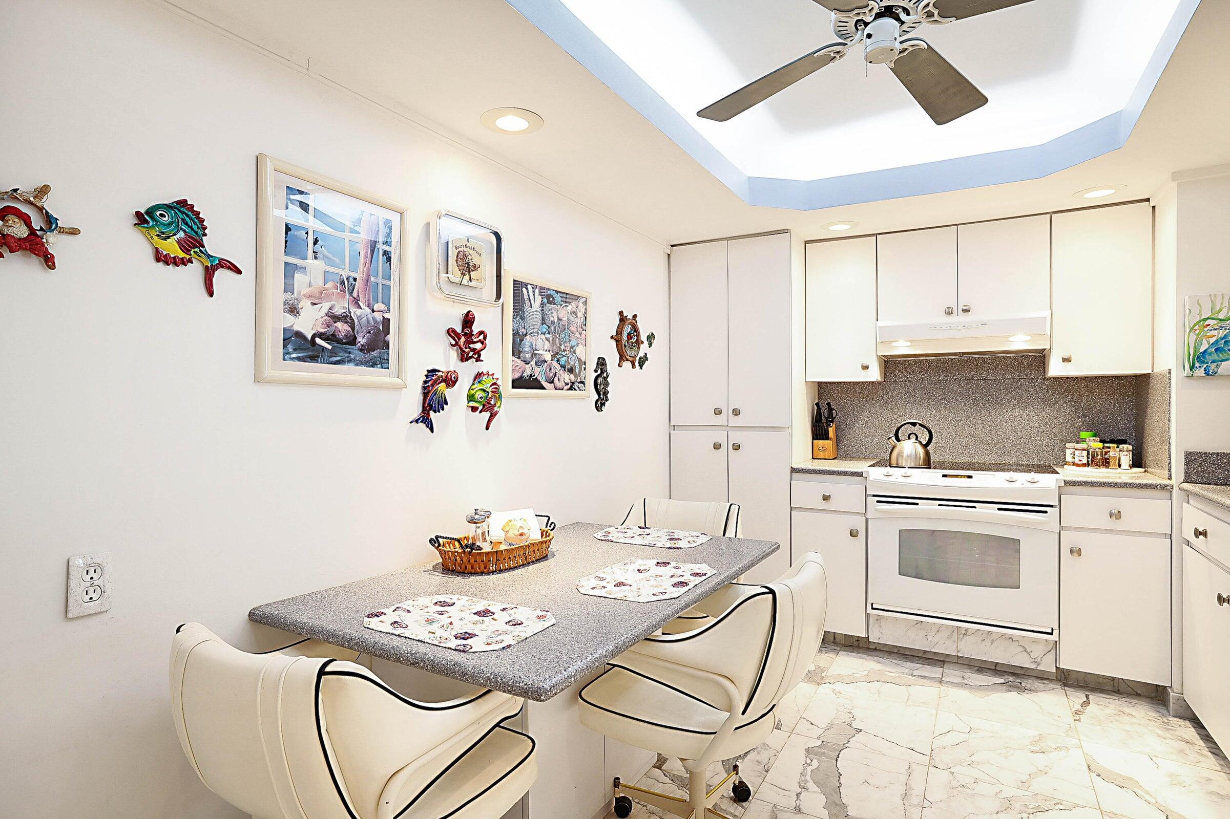 1149 Hillsboro Mile, Unit 310 Hillsboro Beach, FL 33062 - Photo 18 of 33 a kitchen with stainless steel appliances a white table and chairs