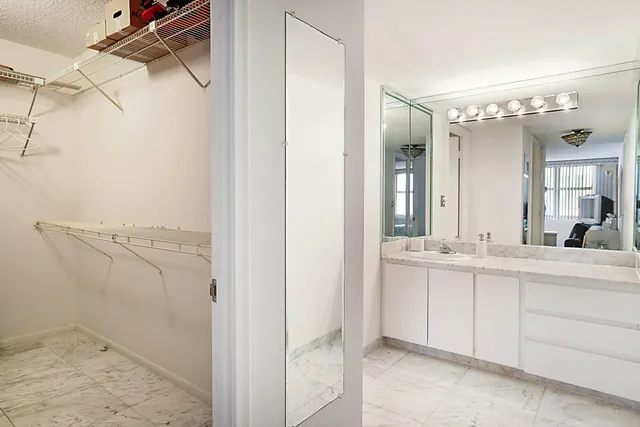 a bathroom with a granite countertop sink mirror and a bath tub
