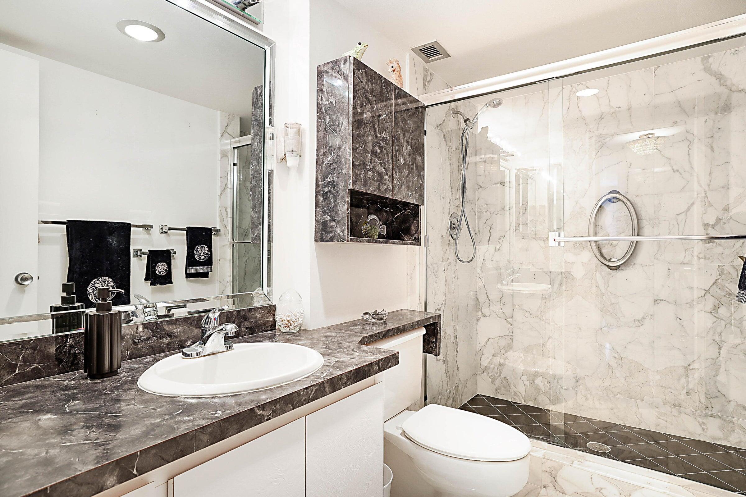 1149 Hillsboro Mile, Unit 310 Hillsboro Beach, FL 33062 - Photo 26 of 33 a bathroom with a sink granite countertop toilet a mirror and shower
