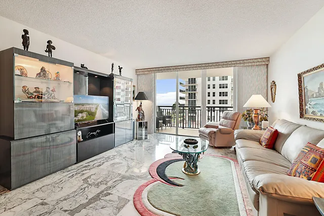 a living room with furniture a flat screen tv and a large window