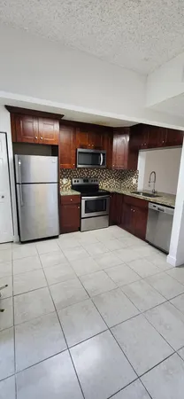 a kitchen with stainless steel appliances a stove a sink and a refrigerator