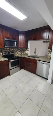 a kitchen with a sink a counter and cabinets