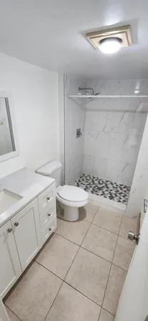 a bathroom with a granite countertop sink a toilet and a mirror