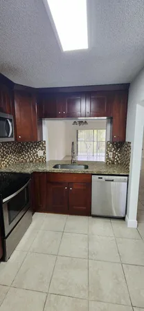 a kitchen with stainless steel appliances granite countertop a sink and cabinets