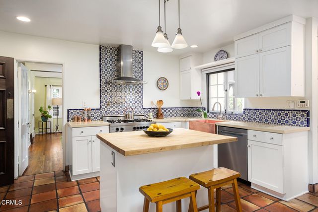a kitchen with a sink a stove and chairs