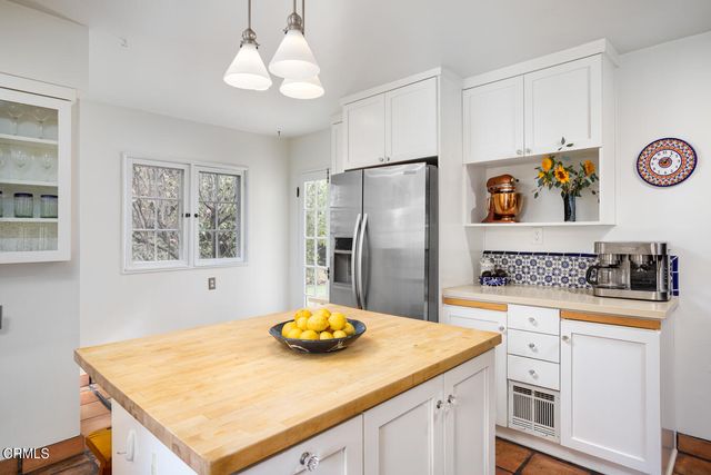 a kitchen with stainless steel appliances a stove a refrigerator and white cabinets