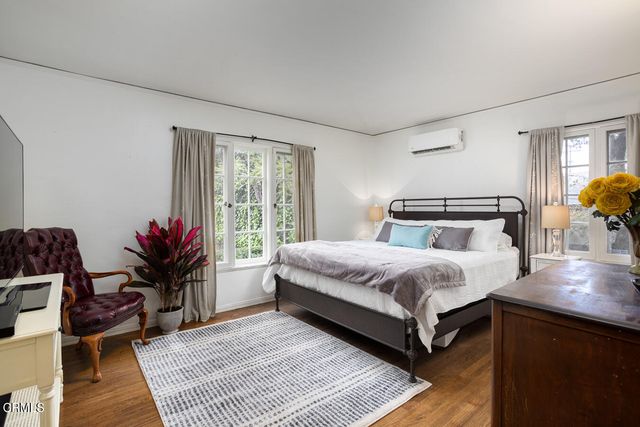 a view of a hallway with wooden floor and living room