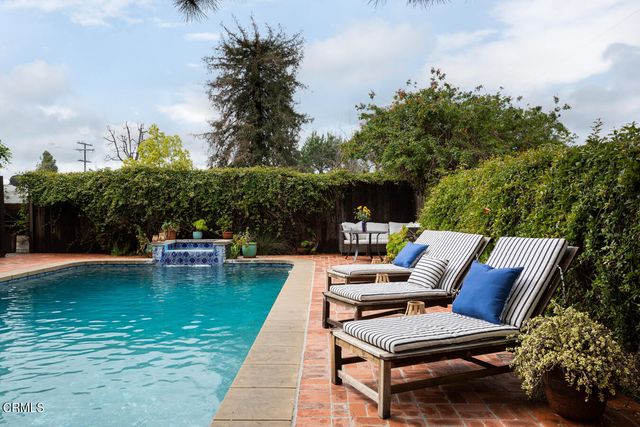 a view of a swimming pool with sitting area and furniture