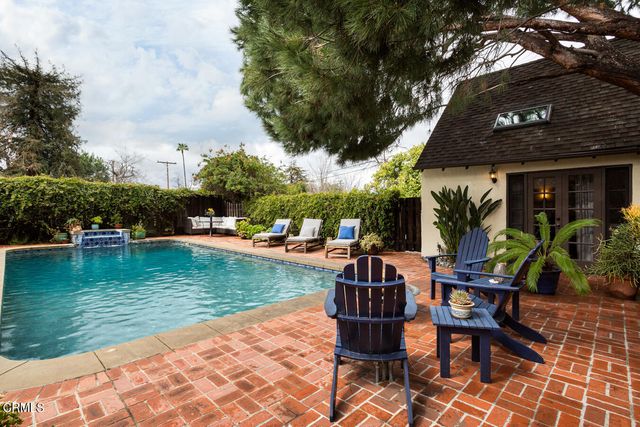 a dining room with furniture a chandelier and glass door