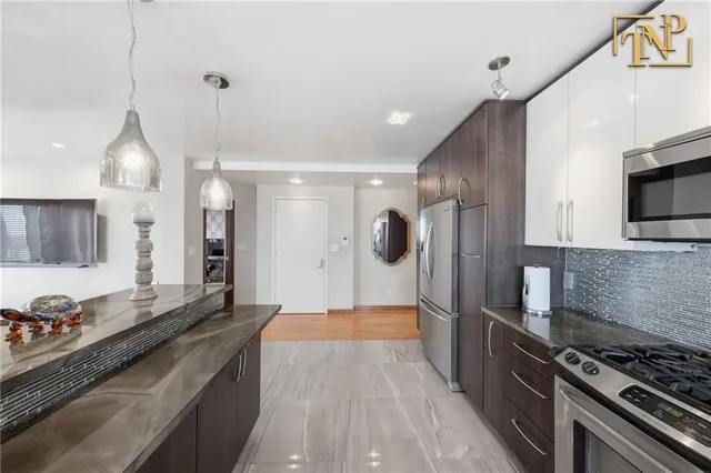 a kitchen with stainless steel appliances granite countertop a stove and a refrigerator