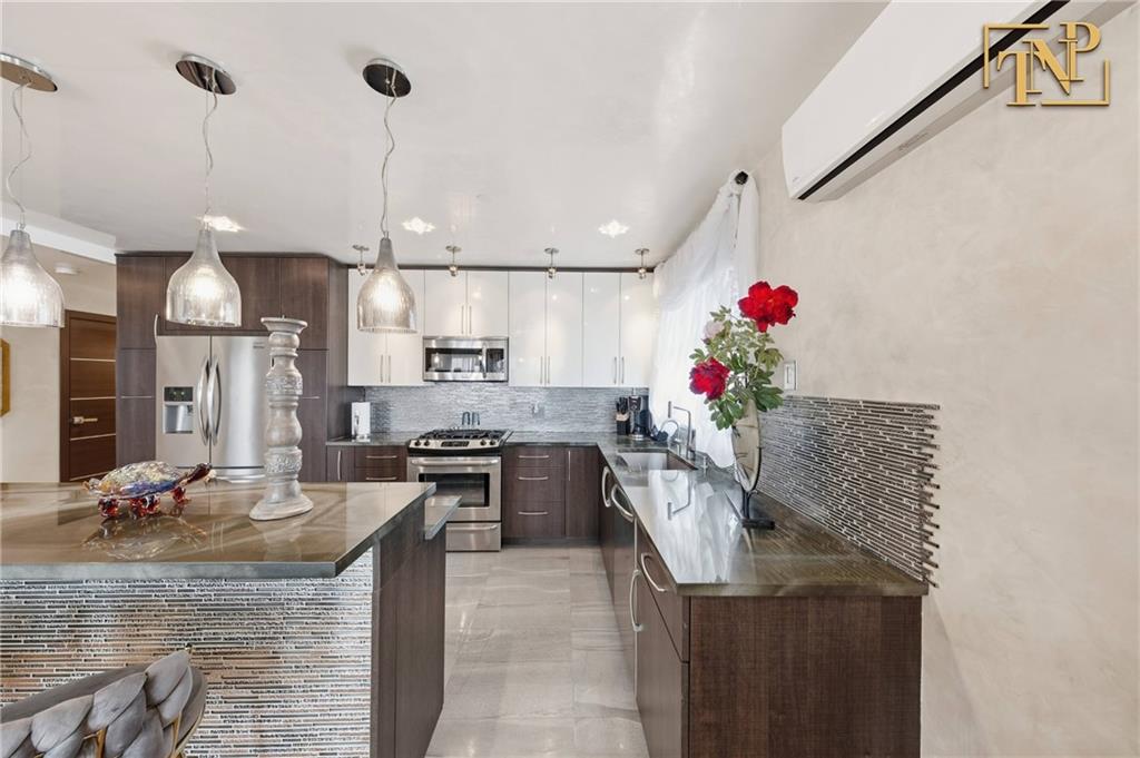 2854 Brighton 4th Street, Unit 6 Brooklyn, NY 11235 - Photo 6 of 19 a very nice looking kitchen with a stove a sink dishwasher and wooden cabinets
