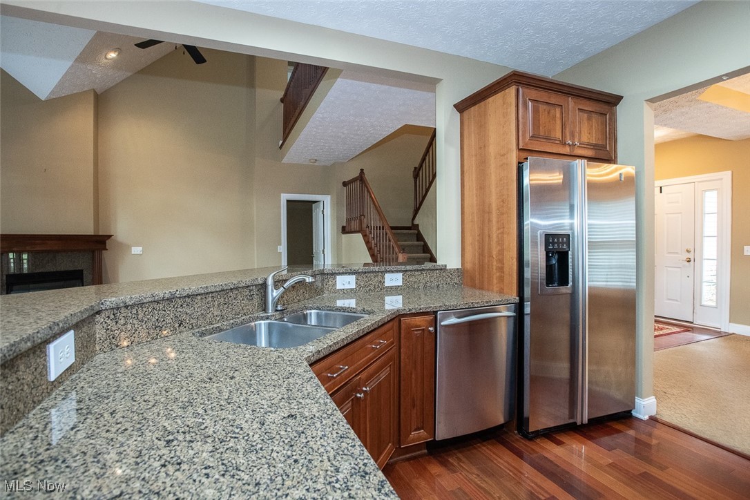 630 Rundle Street Lagrange, OH 44050 - Photo 16 of 49 Kitchen with stainless steel appliances, light stone counters, brown cabinetry, dark wood-type flooring, and a fireplace
