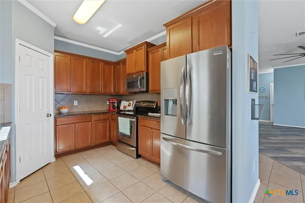 a kitchen with stainless steel appliances granite countertop a refrigerator stove top oven and sink
