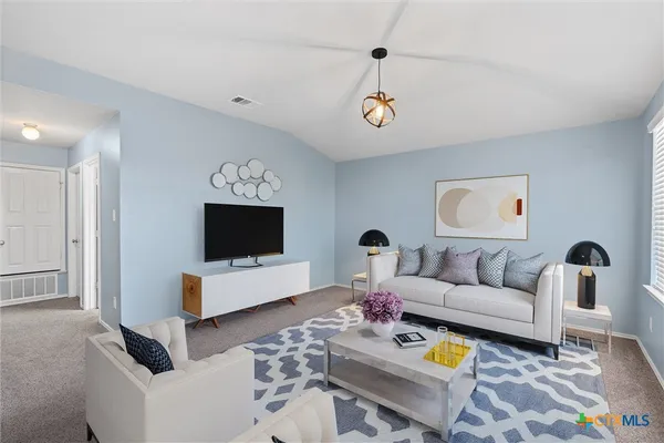 a living room with furniture and wooden floor