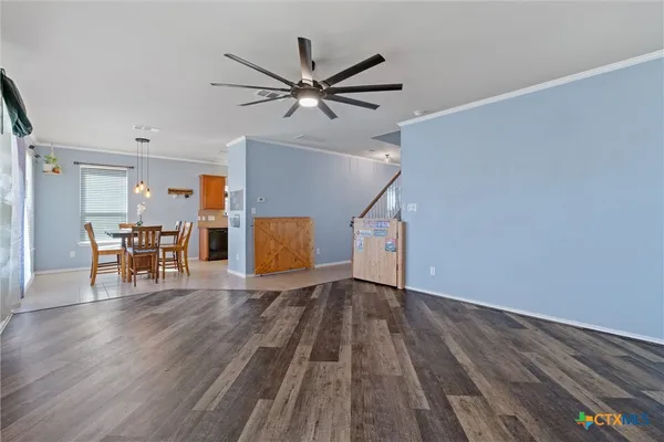a view of a livingroom with wooden floor and a ceiling fan