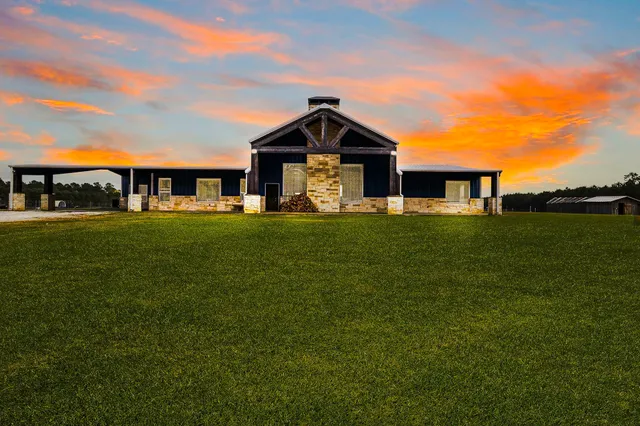 a front view of a house with a yard and trees