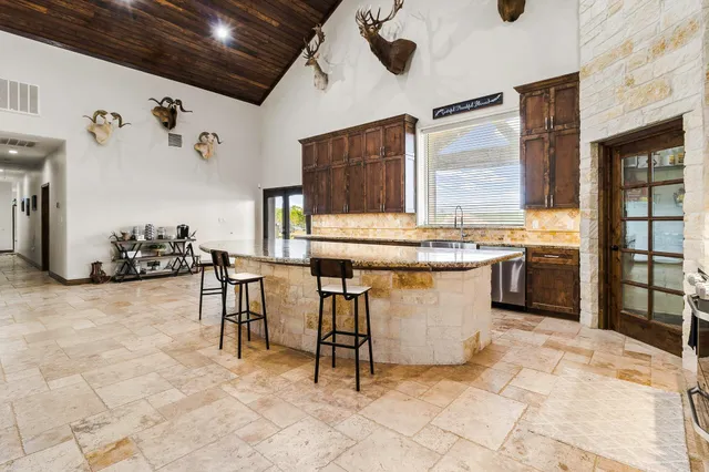a kitchen with stainless steel appliances kitchen island granite countertop a sink and cabinets