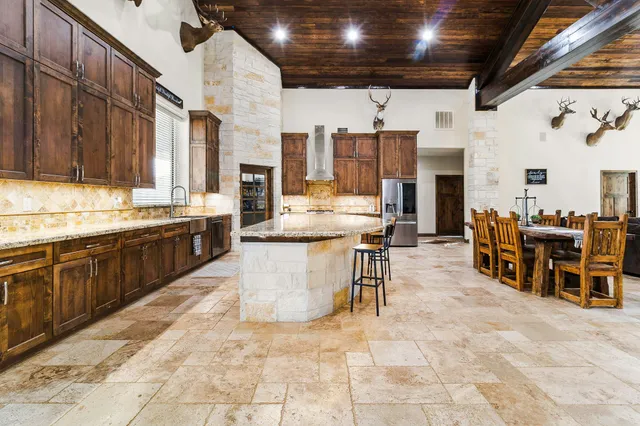 a large dining hall with stainless steel appliances granite countertop a stove and cabinets